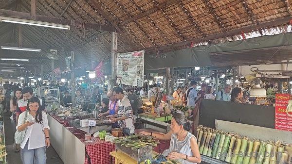 屋根付きの市場通路と飲食店が並ぶ混雑風景