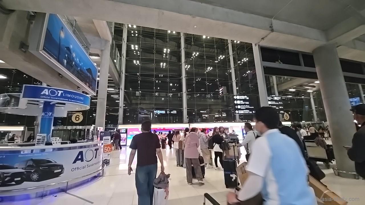 スワンナプーム空港の到着ロビー、深夜でも人が多いガラス張りの広いフロアと両替・案内カウンターの様子