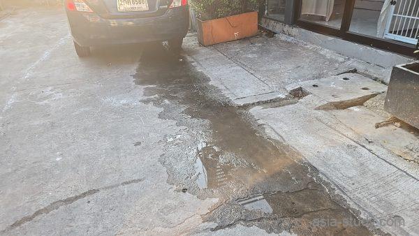 入口付近の床に広がる水たまり、排水の跡が残るコンクリート