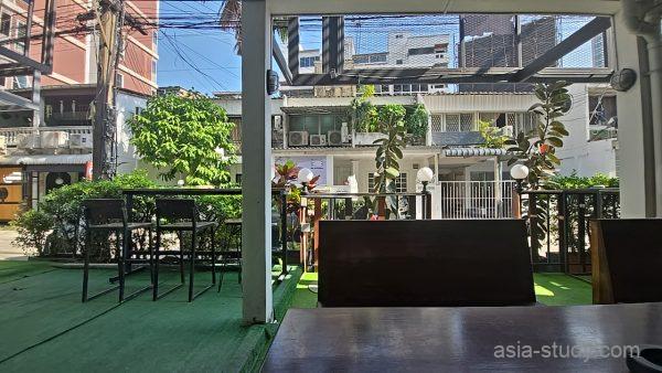 テラス席から見た中庭、カウンターチェアと向かいの建物が見える景色