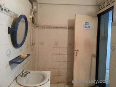 Shadow Inn（シャドウイン）客室バスルームの入口側。洗面台とTOILET表示のドア