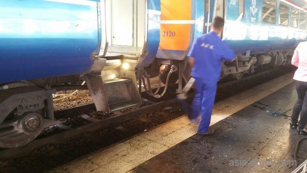 タイ国鉄の車両連結部とホームで作業する駅員