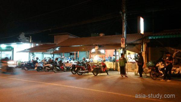 チェンマイの有名店ミッドナイトチキン前に並ぶバイクと夜のローカル食堂